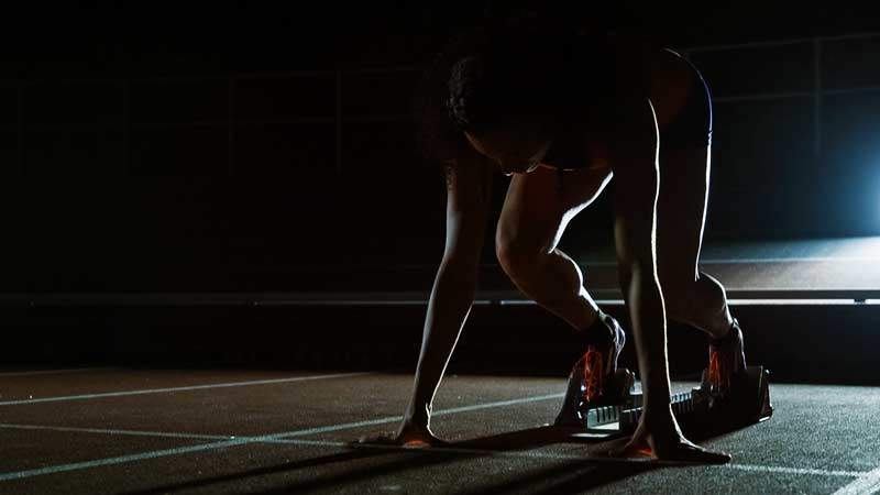 Female athlete demonstrating block starts