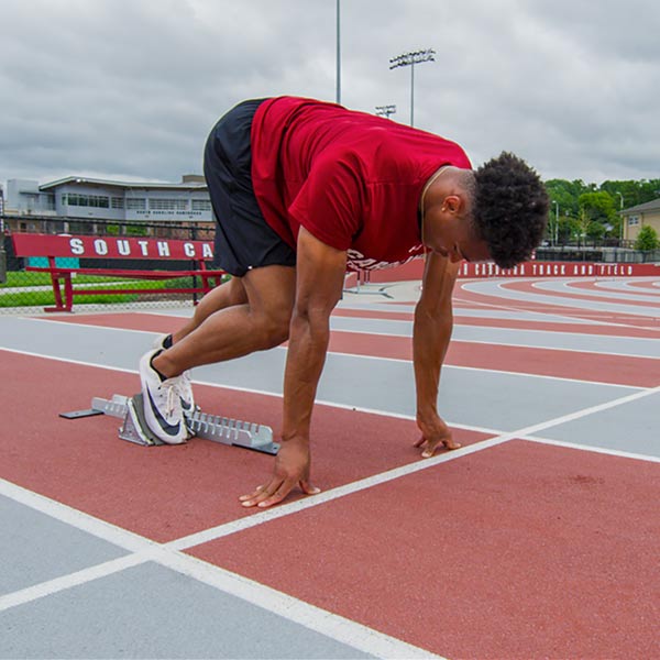elite hurdler performing a block start