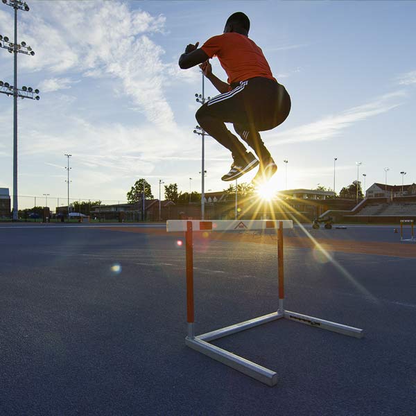 athlete demonstrating hurdle hop sprinting drills for sprint training