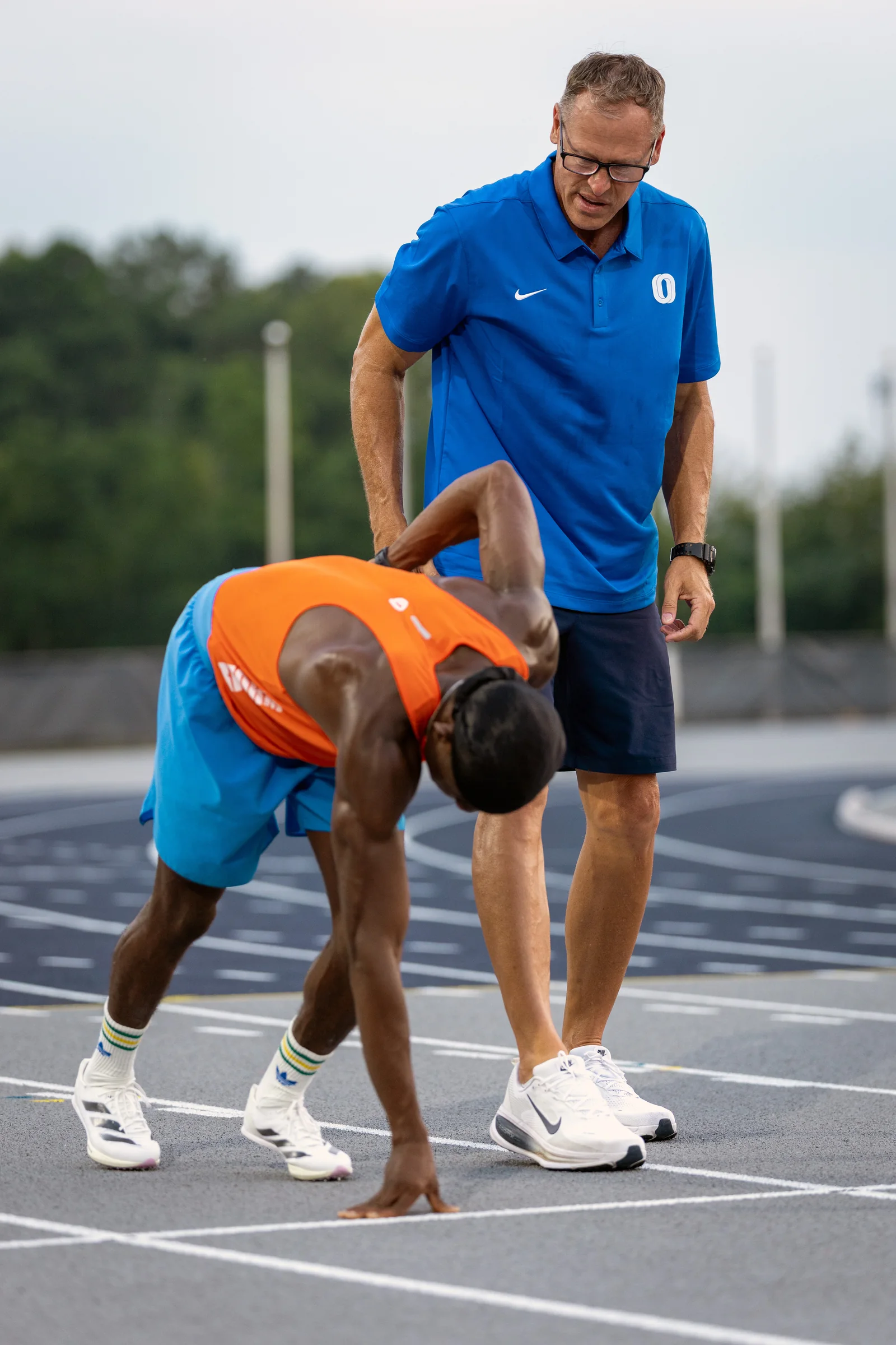 Ken Harnden coaching a sprinter through a block start on the track