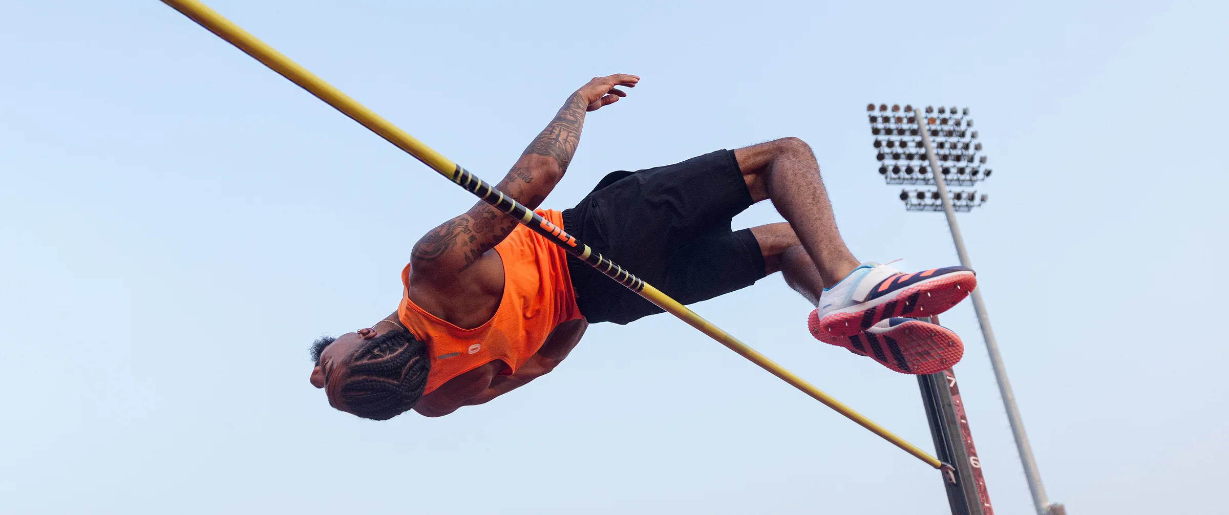 High jumper arched over the bar against the evening sky