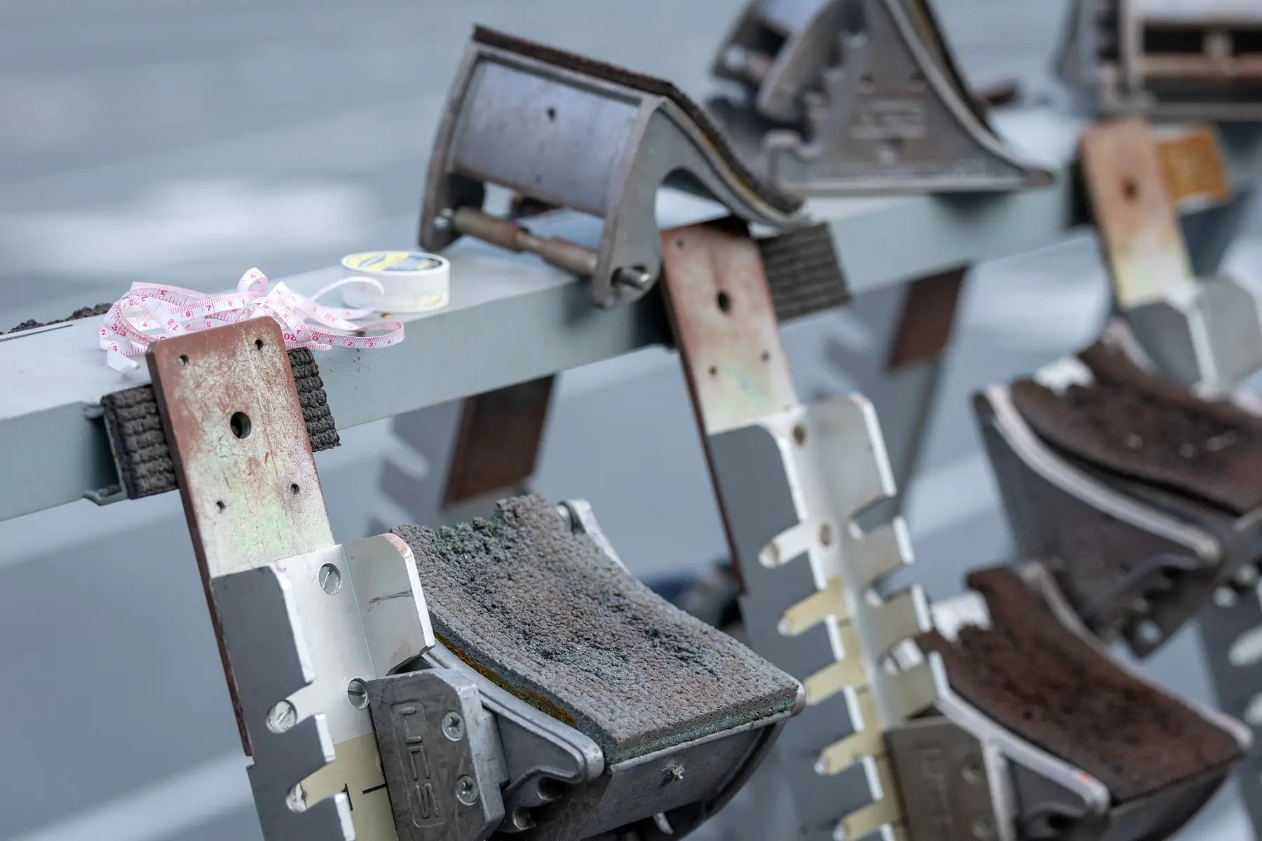 A row of starting blocks racked on a rail, a measuring tape draped over them