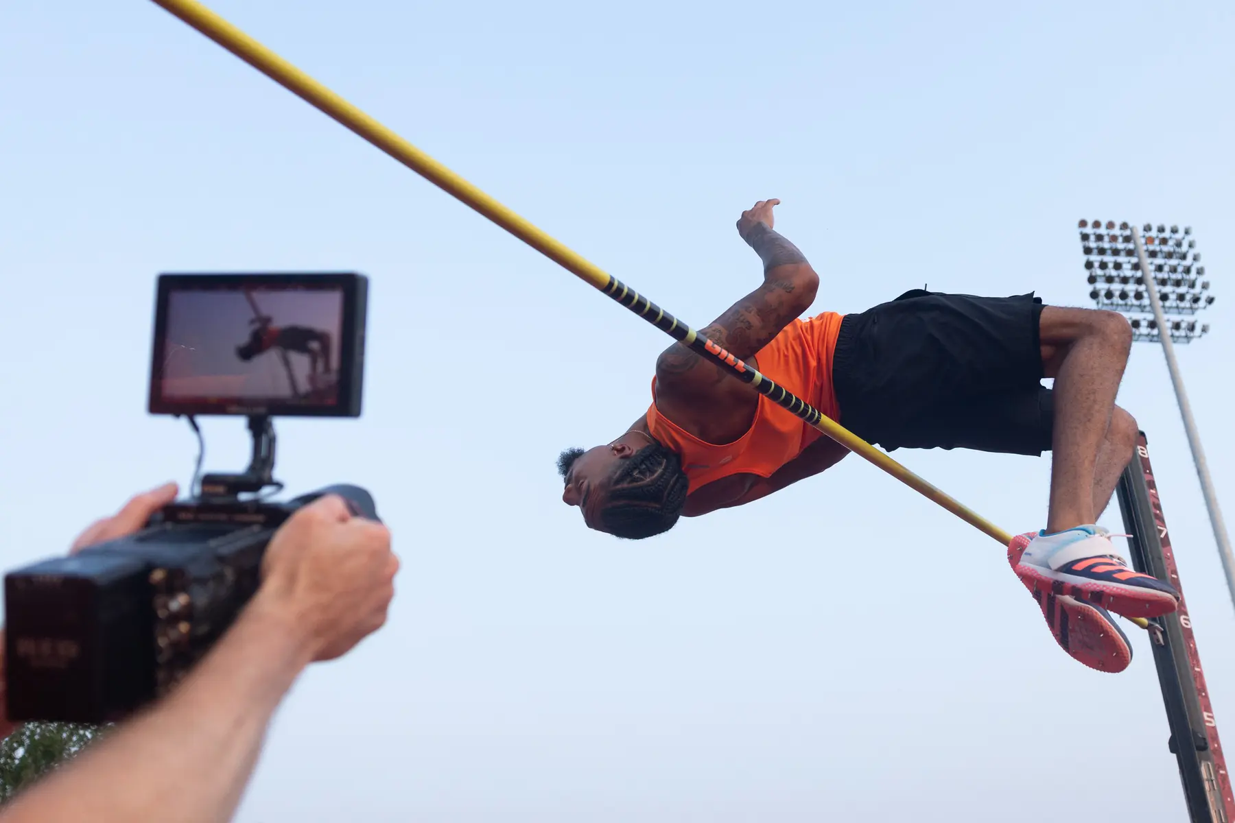 Filming a high jumper clearing the bar, the shot showing on the camera's monitor